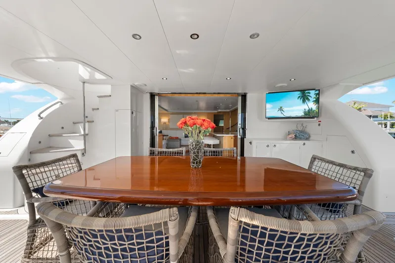 Tranquility Yacht Photos Pics Luxurious Horizon PC60 yacht deck with dining table, chairs, and tropical decor, 2013 model.
