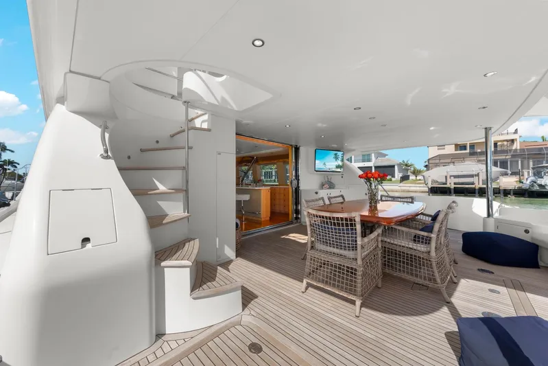 Tranquility Yacht Photos Pics Luxurious Horizon PC60 yacht deck with dining area, spiral staircase, and waterfront view.