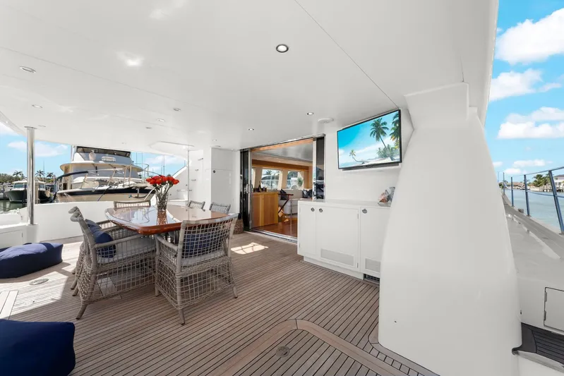 Tranquility Yacht Photos Pics Luxurious 2013 Horizon PC60 yacht deck with dining area, TV, and ocean view.