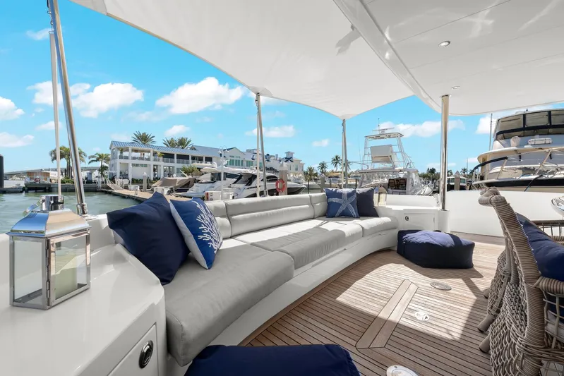 Tranquility Yacht Photos Pics Luxurious Horizon PC60 yacht deck with plush seating, cushions, and marina view.