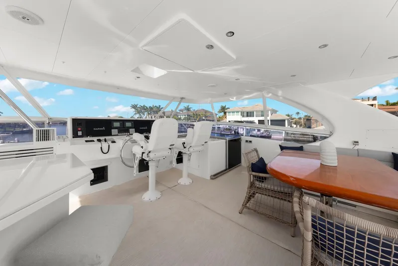 Tranquility Yacht Photos Pics Luxurious 2013 Horizon PC60 yacht interior with helm, seating, and table, overlooking waterfront homes.