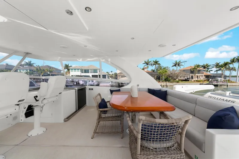 Tranquility Yacht Photos Pics Luxurious Horizon PC60 yacht deck with seating, table, and scenic waterfront view.