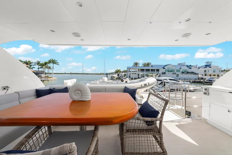 Tranquility Yacht Photos Pics Luxurious Horizon PC60 yacht deck with dining area, marina view, and clear blue sky, 2013 model.