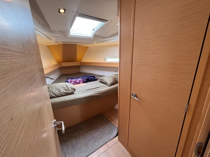 Khushali Yacht Photos Pics Interior cabin of 2019 Jeanneau Sun Odyssey 419 yacht, featuring cozy bedding and natural light.