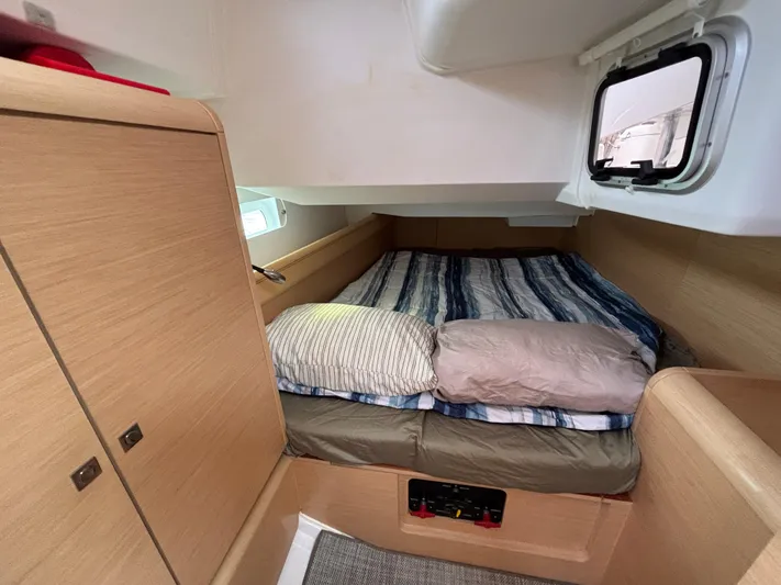 Khushali Yacht Photos Pics Cozy cabin interior of 2019 Jeanneau Sun Odyssey 419 sailboat with striped bedding.