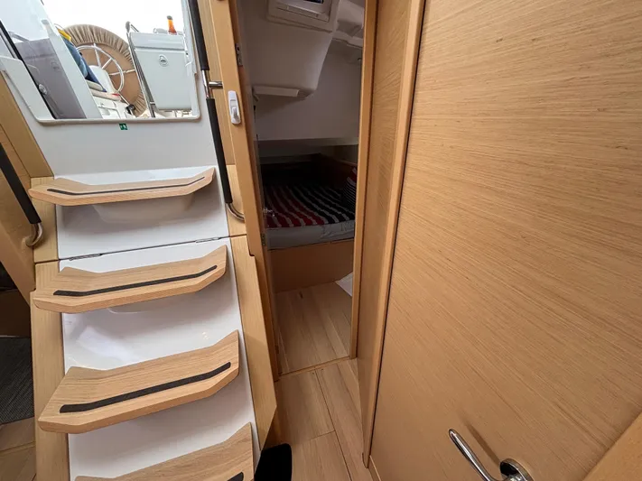 Khushali Yacht Photos Pics Interior of 2019 Jeanneau Sun Odyssey 419 sailboat, featuring wooden stairs and cozy cabin.
