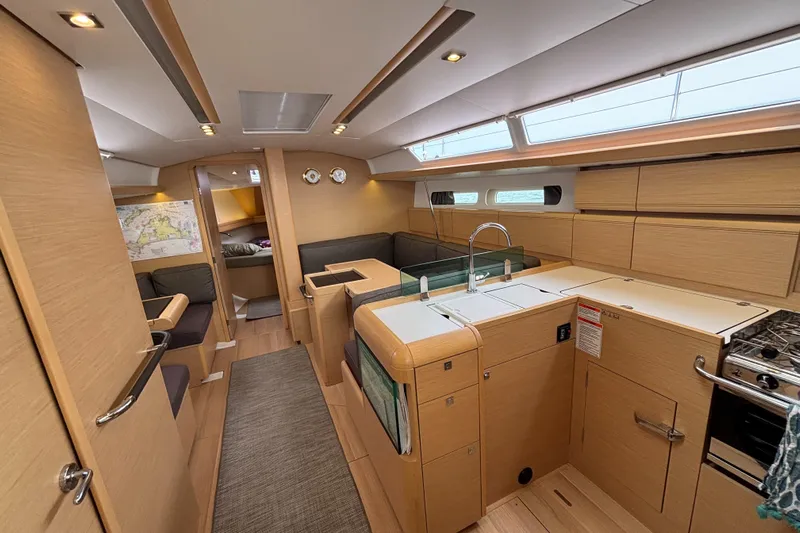 Khushali Yacht Photos Pics 2019 Jeanneau Sun Odyssey 419 interior with modern kitchen and cozy seating area.