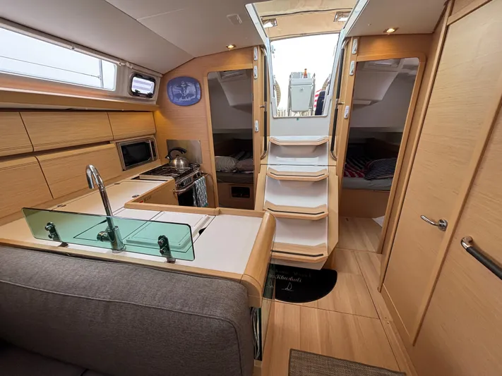 Khushali Yacht Photos Pics Interior of 2019 Jeanneau Sun Odyssey 419 yacht with modern kitchen and cozy seating area.