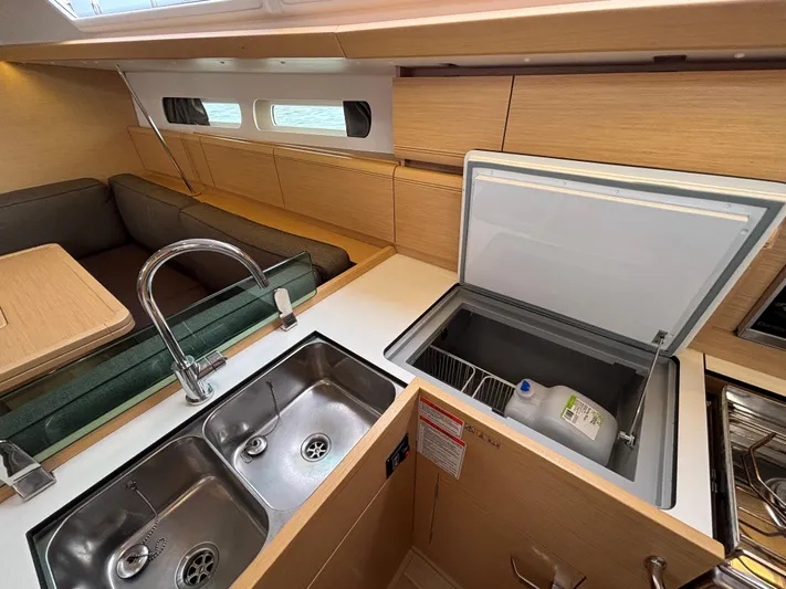 Khushali Yacht Photos Pics Interior of 2019 Jeanneau Sun Odyssey 419 yacht, featuring kitchen sink and open fridge.