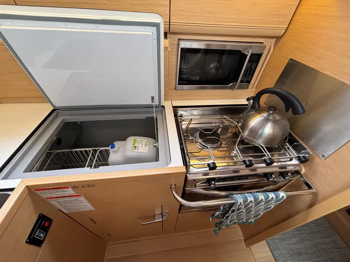 Khushali Yacht Photos Pics Galley of 2019 Jeanneau Sun Odyssey 419 with stove, kettle, and open fridge.