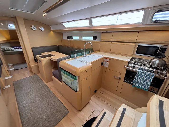 Khushali Yacht Photos Pics Interior of 2019 Jeanneau Sun Odyssey 419 sailboat with modern kitchen and seating area.