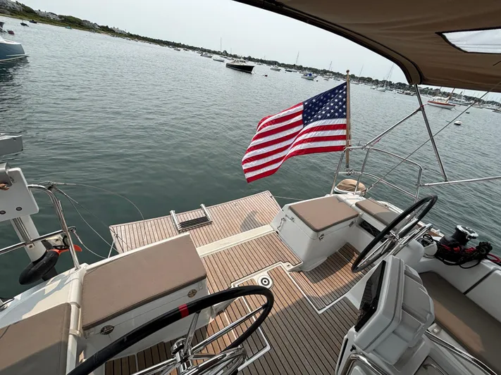 Khushali Yacht Photos Pics 2019 Jeanneau Sun Odyssey 419 sailboat with American flag, docked in a serene harbor.
