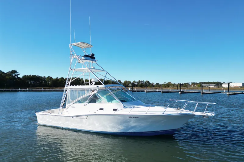 Sea Dated Yacht Photos Pics 1996 Cabo 35 boat on calm water with clear blue sky background.
