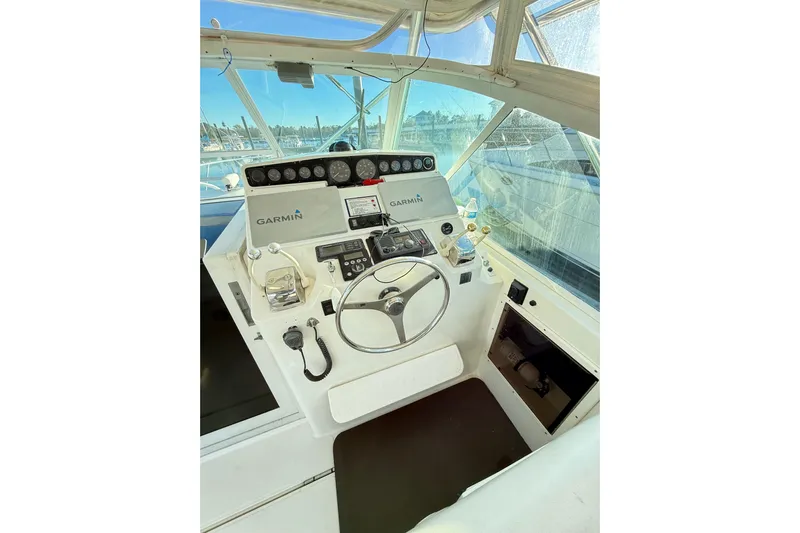 Sea Dated Yacht Photos Pics 1996 Cabo 35 boat helm with Garmin navigation system and steering wheel.