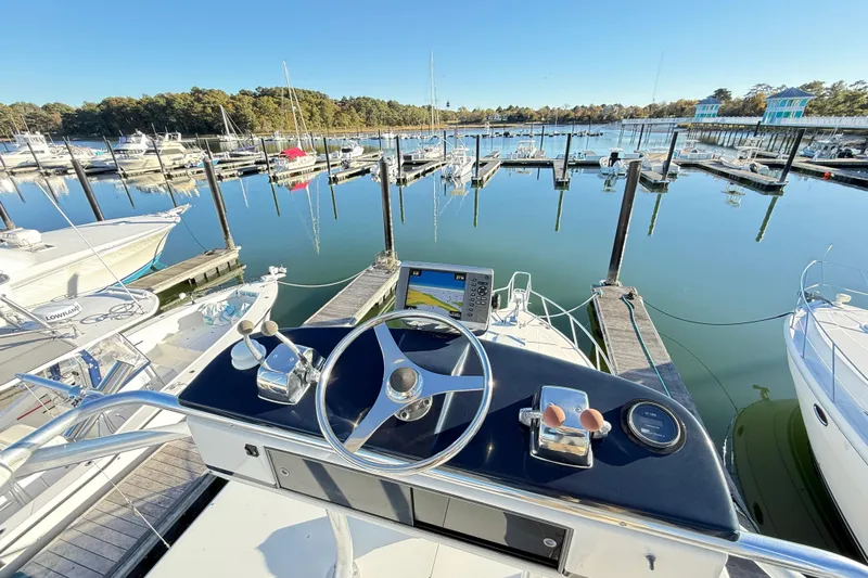 Sea Dated Yacht Photos Pics Helm view of a 1996 Cabo 35 yacht docked in a serene marina.