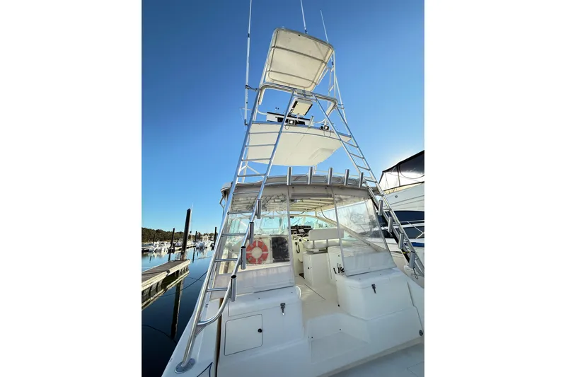 Sea Dated Yacht Photos Pics 1996 Cabo 35 boat with tower ladder, docked at marina under clear blue sky.