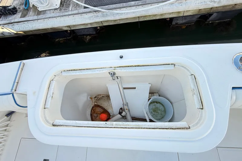 Sea Dated Yacht Photos Pics Open storage compartment on a 1996 Cabo 35 boat, containing a bucket and fishing gear.