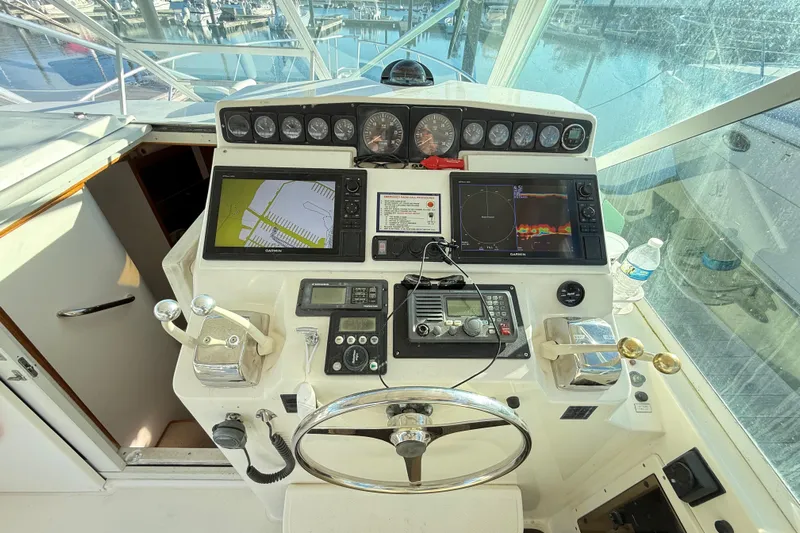 Sea Dated Yacht Photos Pics Control panel of a 1996 Cabo 35 boat with navigation equipment and steering wheel.