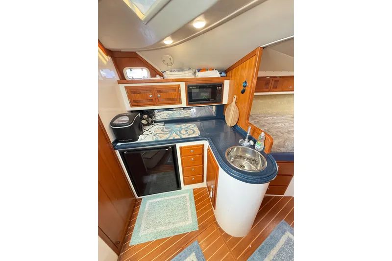 Sea Dated Yacht Photos Pics 1996 Cabo 35 yacht interior kitchen with wood cabinetry, sink, and appliances.