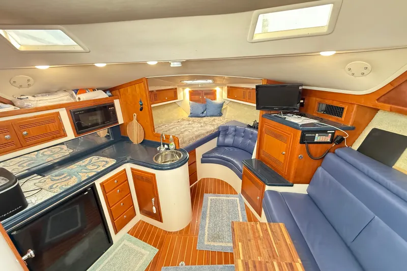 Sea Dated Yacht Photos Pics Luxurious 1996 Cabo 35 yacht interior with kitchen, seating, and sleeping area.