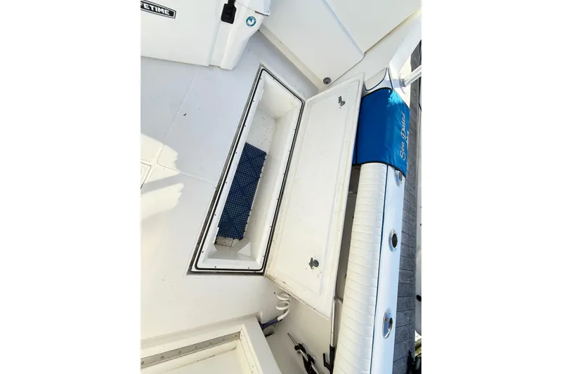 Sea Dated Yacht Photos Pics 1996 Cabo 35 boat deck with storage compartment and blue cushion.