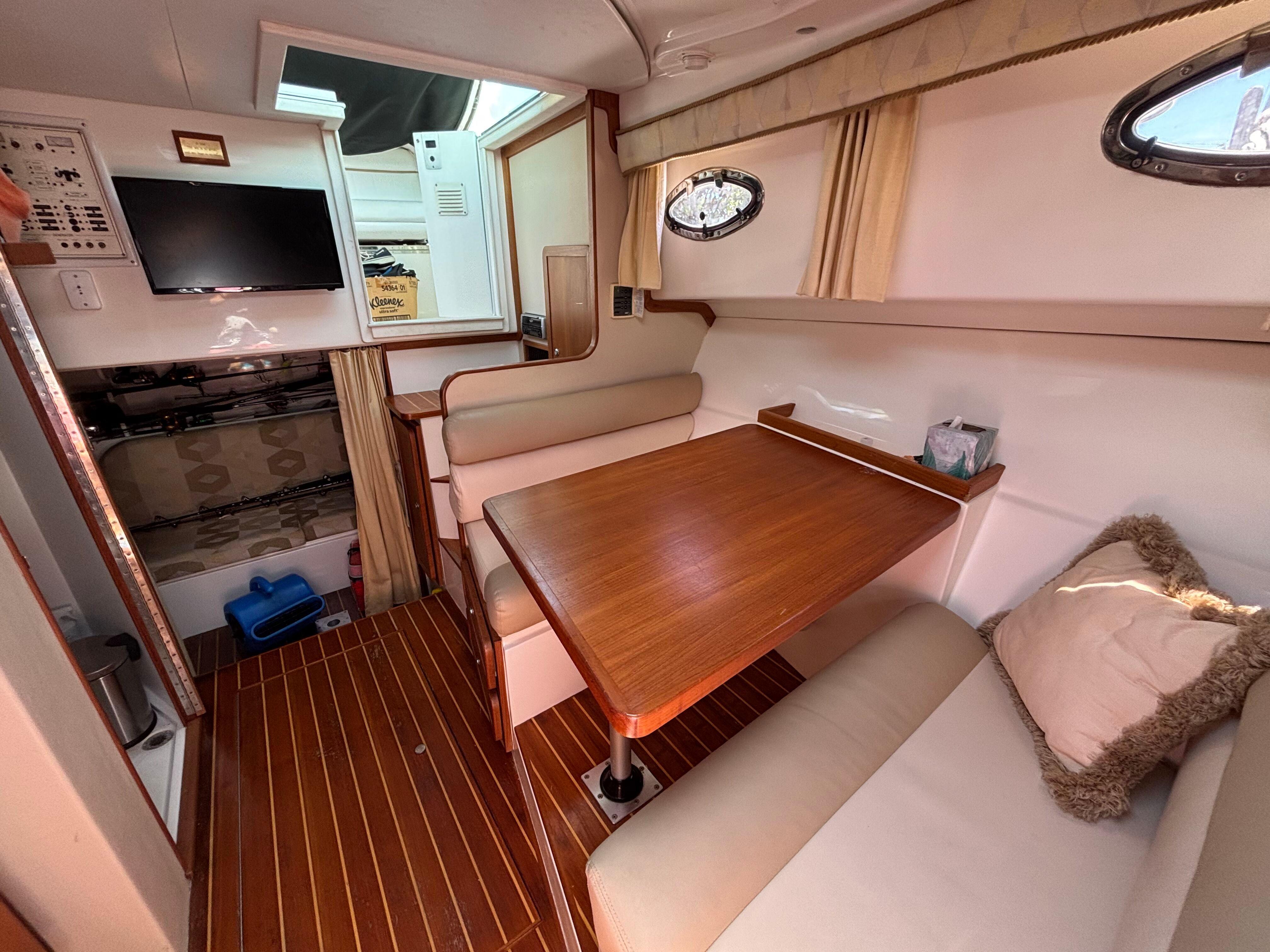 2004 Stamas 320 Express cabin interior with dining area and TV.
