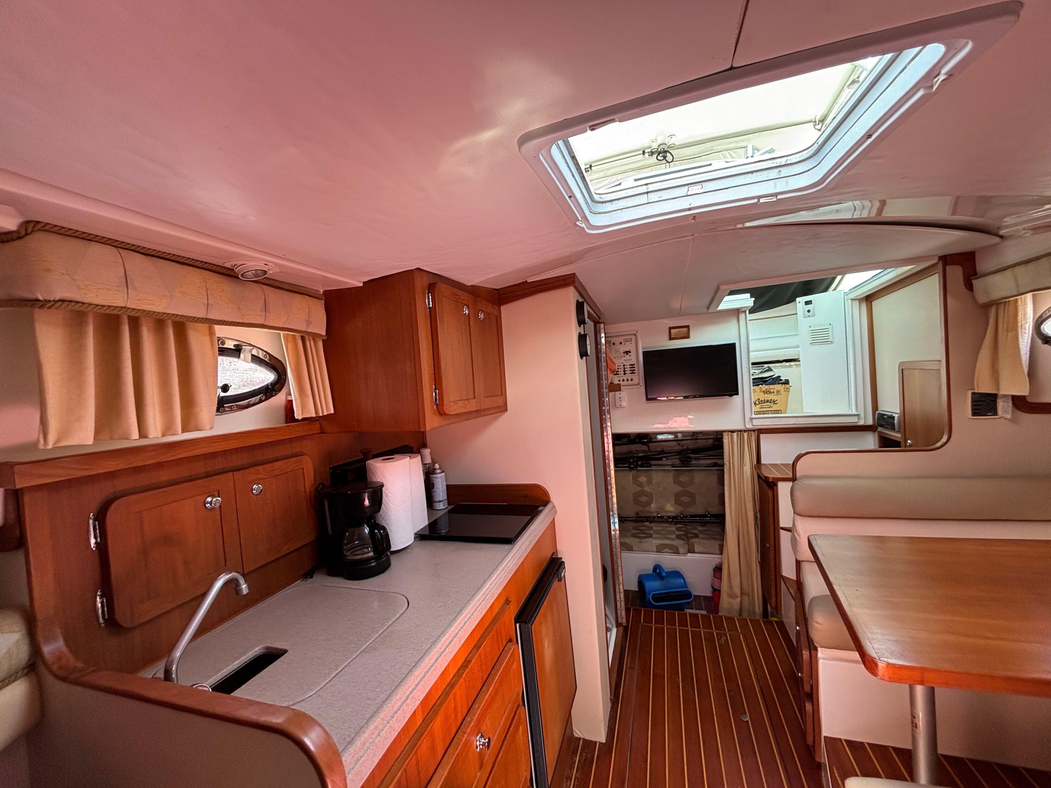 2004 Stamas 320 Express cabin interior with kitchenette, dining area, and skylight.
