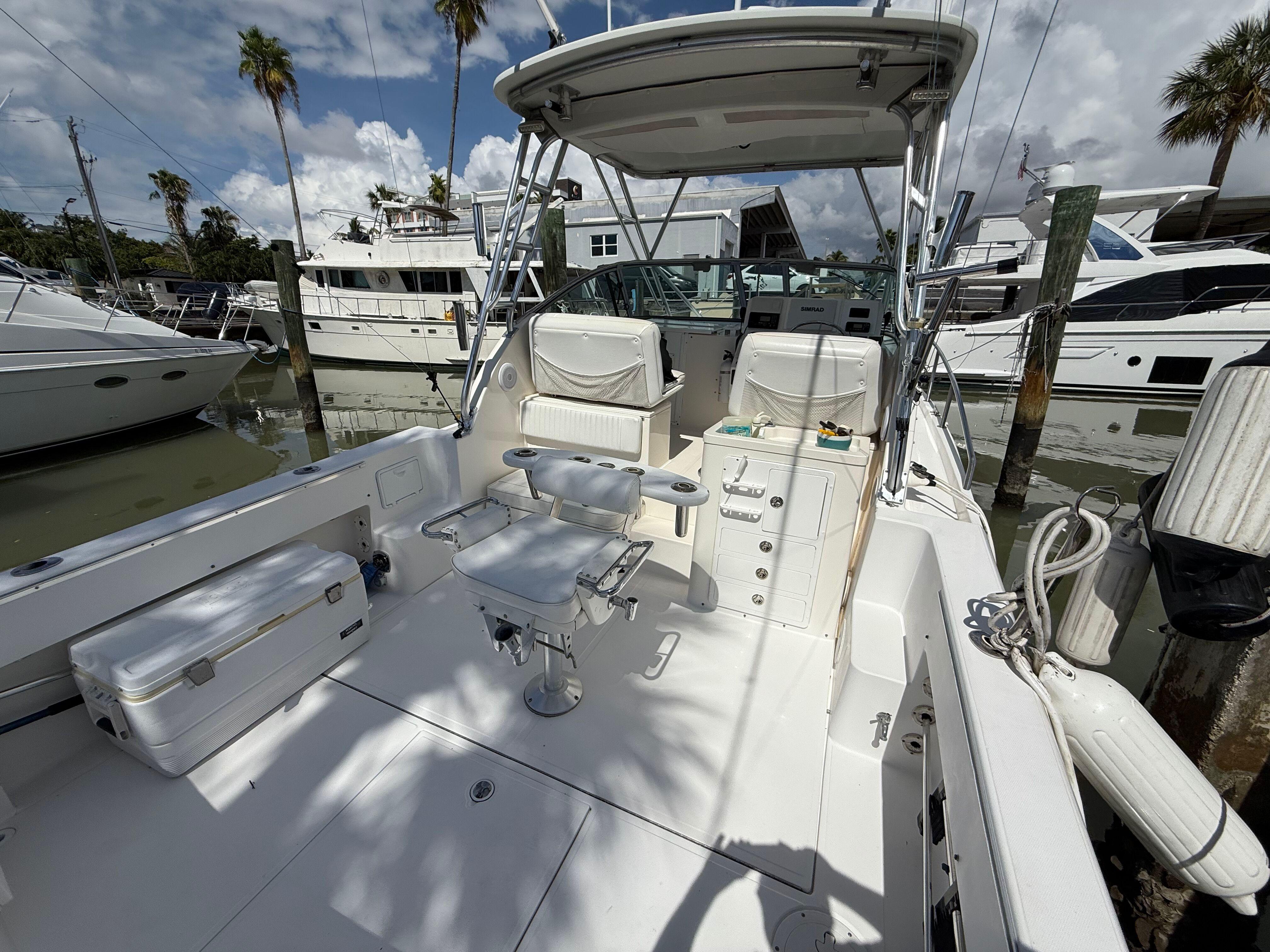 2004 Stamas 320 Express boat docked, featuring spacious deck and seating under a clear sky.