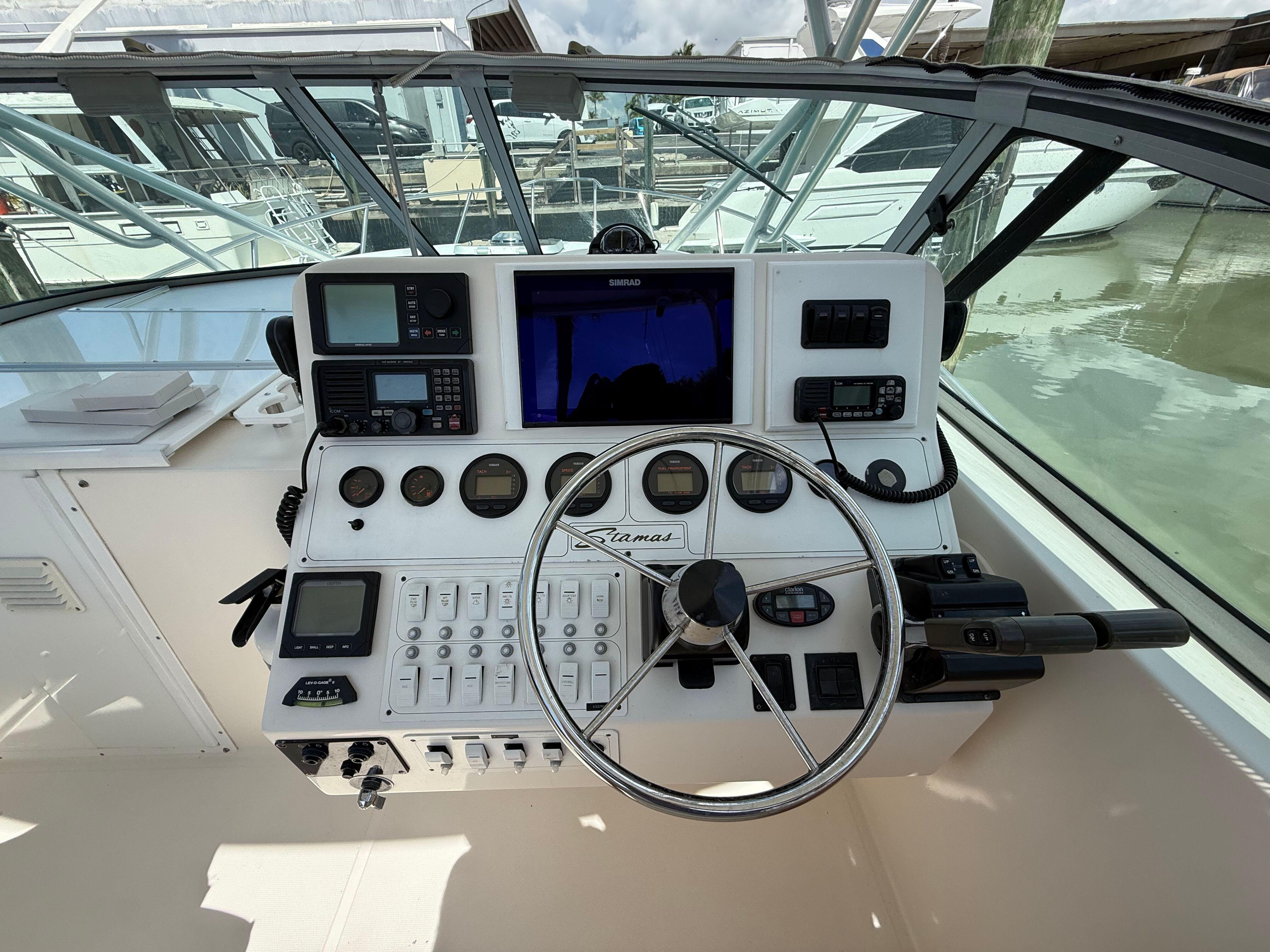 2004 Stamas 320 Express boat dashboard with navigation instruments and steering wheel.