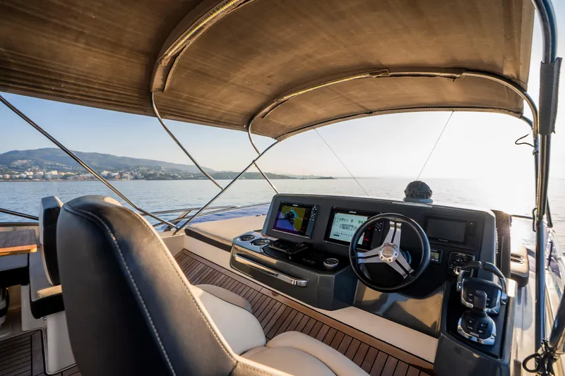 Valluga Yacht Photos Pics Cockpit view of 2018 Bavaria R55 yacht with navigation screens and steering wheel.