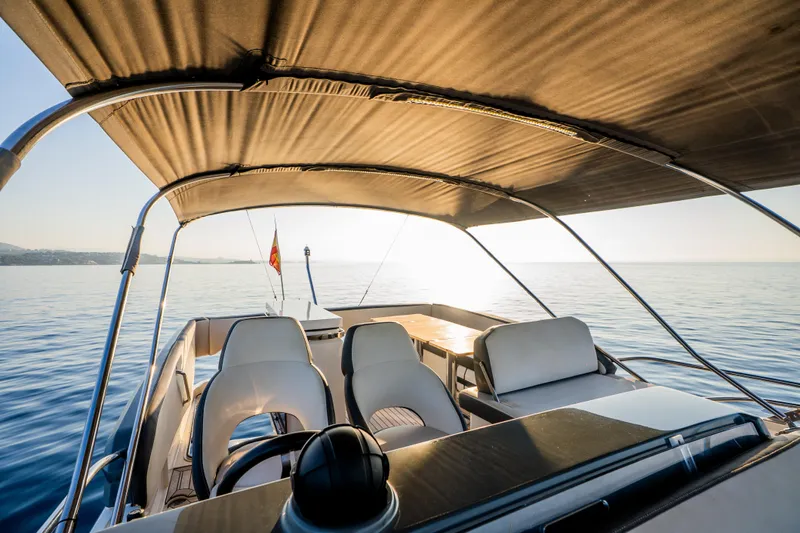 Valluga Yacht Photos Pics Luxury Bavaria R55 yacht interior, 2018 model, with sunlit ocean view and elegant seating.