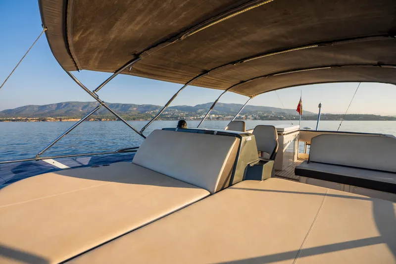 Valluga Yacht Photos Pics Luxurious 2018 Bavaria R55 yacht deck with seating, scenic ocean view, and mountains in the background.