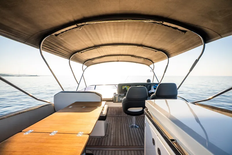 Valluga Yacht Photos Pics Luxurious 2018 Bavaria R55 yacht interior with wooden deck and seating, cruising on calm waters.