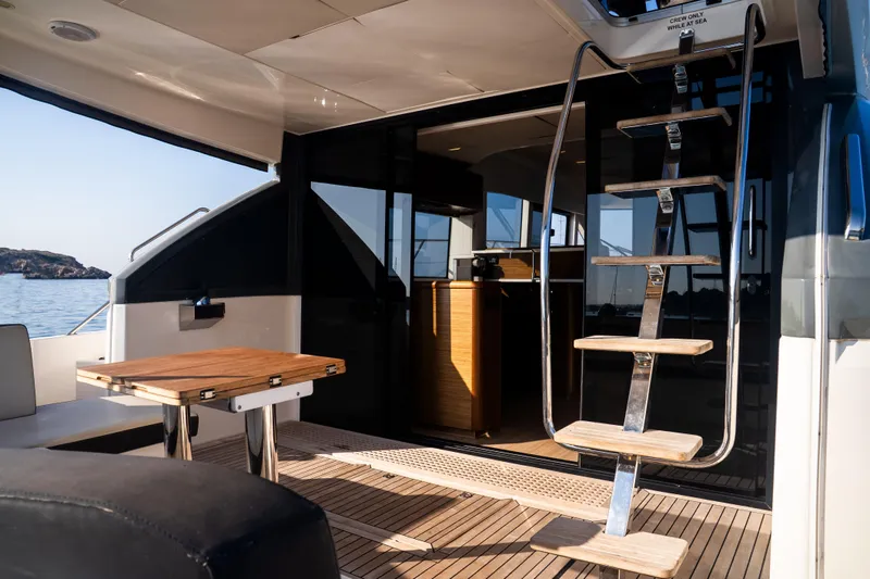 Valluga Yacht Photos Pics Luxurious 2018 Bavaria R55 yacht interior with wooden table and sleek staircase.