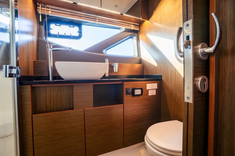 Valluga Yacht Photos Pics Luxurious 2018 Bavaria R55 yacht bathroom with modern fixtures and wooden cabinetry.