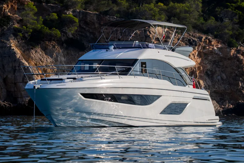 Valluga Yacht Photos Pics Luxurious 2018 Bavaria R55 yacht cruising near rocky coastline.