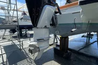 2023 Saxdor 320 GTO boat with powerful outboard motor, docked under clear blue sky.