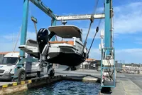 2023 Saxdor 320 GTO boat being lifted by a crane at a marina.