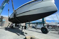 2023 Saxdor 320 GTO boat lifted by crane in a marina setting.