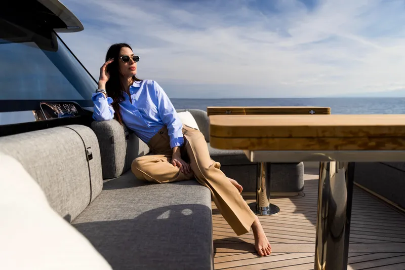  Yacht Photos Pics Woman relaxing on Invictus ST550 yacht, 2025 model, enjoying ocean view.