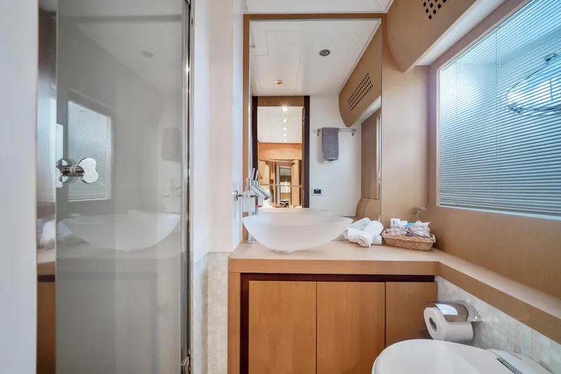 Shadow Yacht Photos Pics Luxurious bathroom on a 2007 Pershing 90 yacht with modern fixtures and wooden cabinetry.