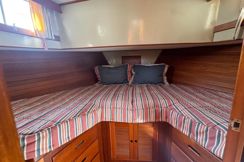 Good Enough Yacht Photos Pics Cozy cabin interior of 1990 Grand Banks 46 Classic with striped bedding.