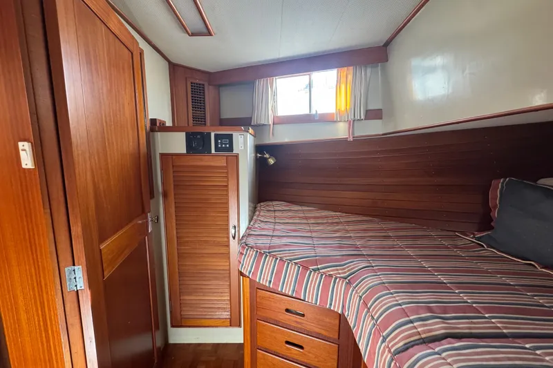 Good Enough Yacht Photos Pics Cozy cabin interior of 1990 Grand Banks 46 Classic yacht with wood paneling and striped bedding.