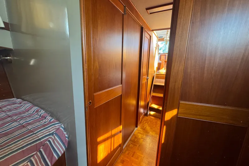 Good Enough Yacht Photos Pics 1990 Grand Banks 46 Classic yacht interior with wooden paneling and striped bedding.