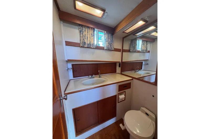 Good Enough Yacht Photos Pics Bathroom interior of 1990 Grand Banks 46 Classic yacht, featuring sink, mirror, and toilet.