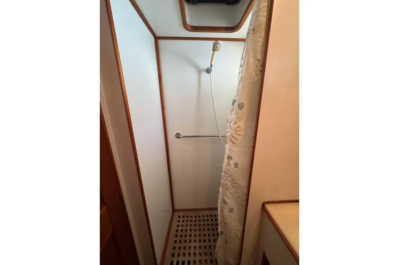 Good Enough Yacht Photos Pics Shower area in 1990 Grand Banks 46 Classic yacht with curtain and wooden accents.