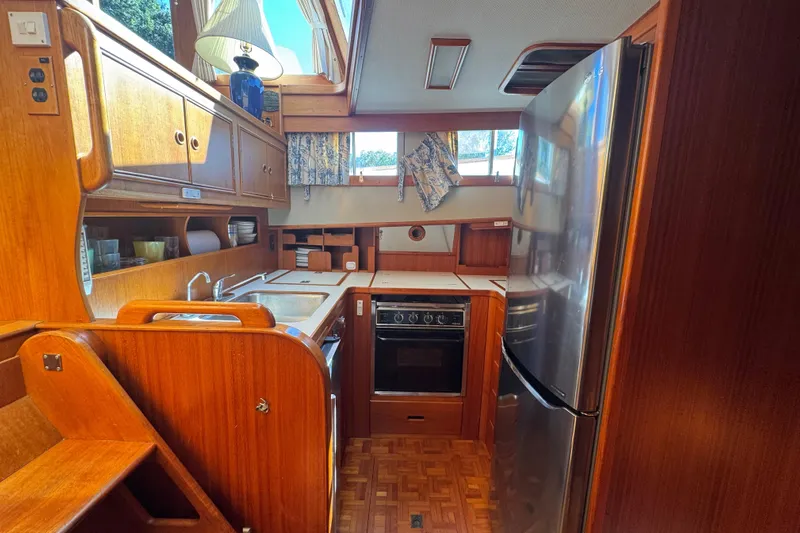 Good Enough Yacht Photos Pics Interior of 1990 Grand Banks 46 Classic yacht kitchen with wood cabinetry and stainless steel appliances.