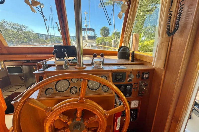 Good Enough Yacht Photos Pics Interior helm of 1990 Grand Banks 46 Classic yacht with wooden steering wheel and control panel.
