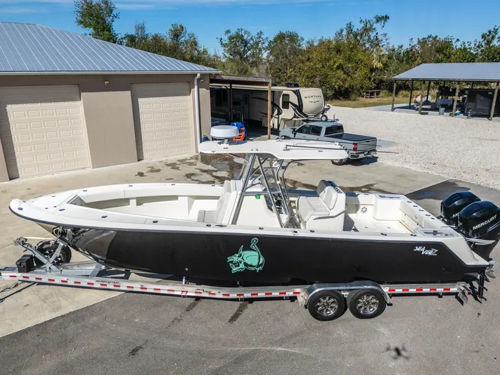 Pilar Yacht Photos Pics 2019 SeaVee 322z boat on trailer, parked near garages and trees.