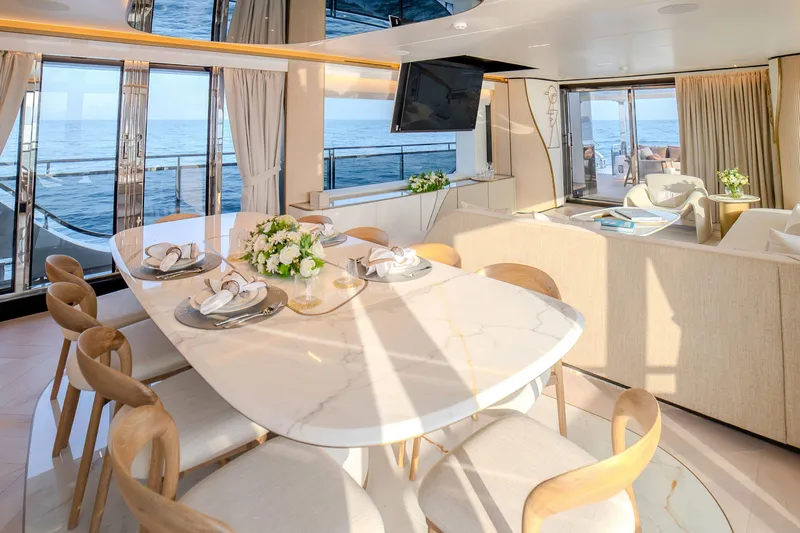  Yacht Photos Pics Luxurious interior of 2027 Majesty 100 Terrace yacht with elegant dining area and ocean view.
